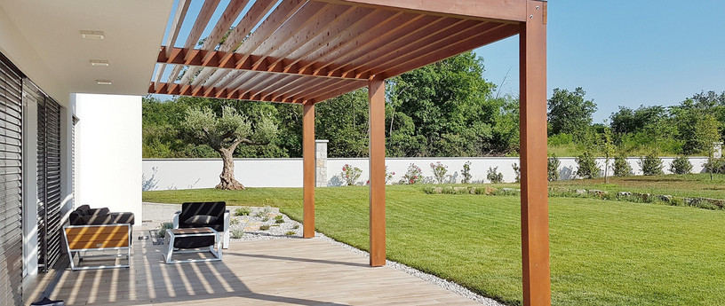 Carport mit Holzdach als Unterstand für ein geparktes Auto.
