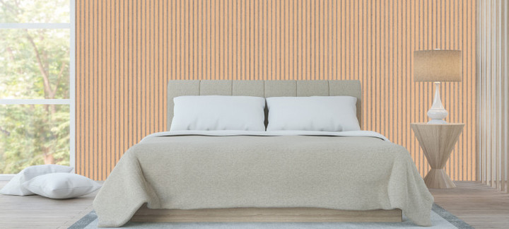 Akustikpaneele aus Holz an der Wand eines Schlafzimmers, davor ein Doppelbett mit dekorativen Kissen und Stehlampe.