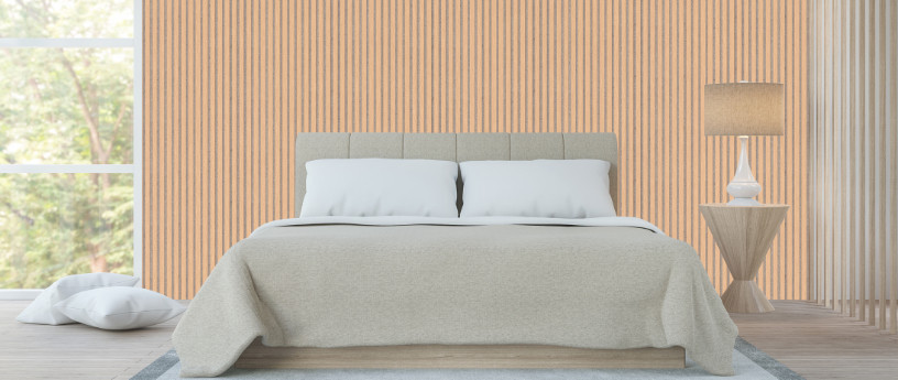 Akustikpaneele aus Holz an der Wand eines Schlafzimmers, davor ein Doppelbett mit dekorativen Kissen und Stehlampe.