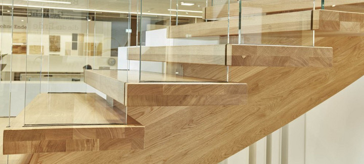 Moderne Holztreppe mit Glasgeländer und massiven Stufen aus Eichenholz in zeitgemäßem Design.