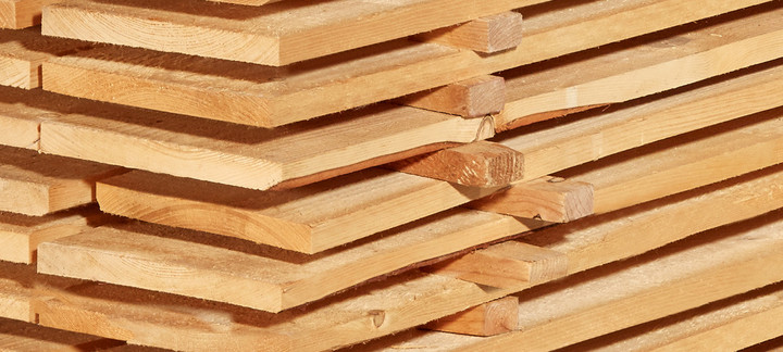 Gestapelte Schalbretter aus Holz mit sägerauer Oberfläche, ideal für den Bau- und Konstruktionsbereich.