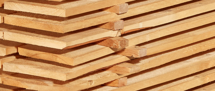 Gestapelte Schalbretter aus Holz mit sägerauer Oberfläche, ideal für den Bau- und Konstruktionsbereich.