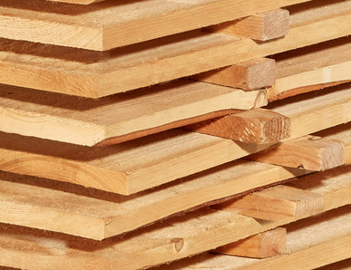 Gestapelte Schalbretter aus Holz mit sägerauer Oberfläche, ideal für den Bau- und Konstruktionsbereich.