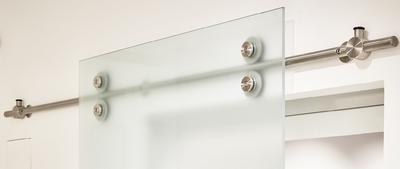 Schiebetüren aus Milchglas mit sichtbarer Stange und Gleiträdern.