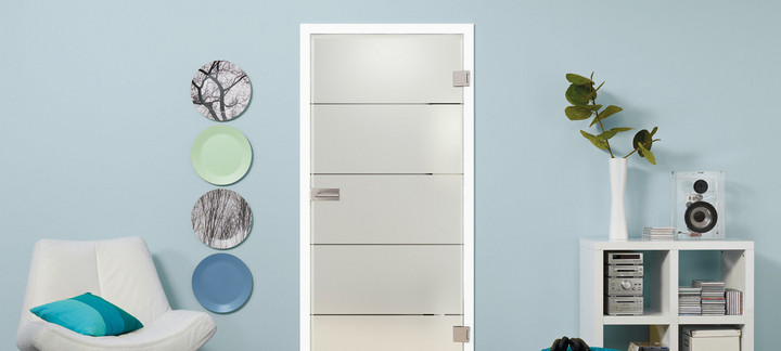 Glastür aus satiniertem Glas mit vier quer verlaufenden Streifen. Die Tür steht vor einer blauen Wand. Links und rechts sind dekorative Elemente sichtbar.